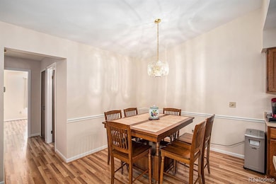 Dining area with light wood-type flooring and a chandelier