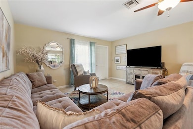 Tiled living room with ceiling fan and view of fro