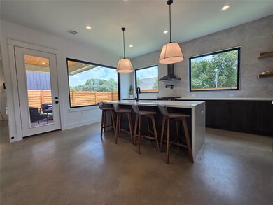 Kitchen featuring light countertops, concrete flo