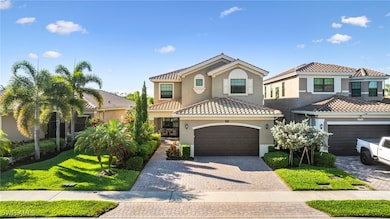 Two-story house featuring a garage, driveway, a tile roof, and stucco siding
