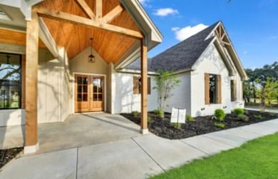 Property entrance with covered porch, stucco siding, and french doors