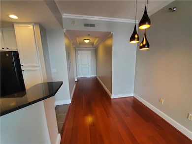 Hall with crown molding and dark wood-type flooring