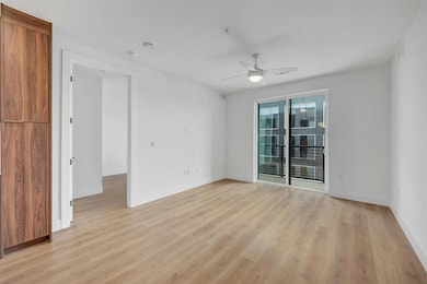 Spare room featuring a ceiling fan and light wood