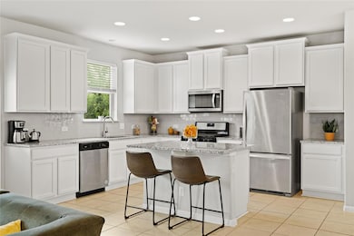 Kitchen with light tile patterned flooring, a sin