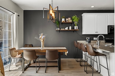 Dining space featuring light wood-style flooring, recessed lighting, a chandelier, and baseboards