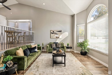Sitting room featuring wood finished floors, high vaulted ceiling, and a ceiling fan