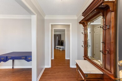 Hallway with crown molding, a textured ceiling, ba
