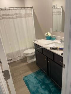 Bathroom featuring dark wood finished floors, vanity, and a shower with curtain