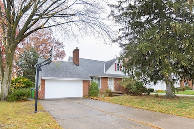 Cape cod home with a front lawn, brick siding, a chimney, driveway, and an attached garage
