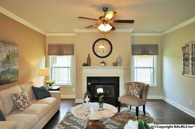 The living showcases a natural gas fireplace, crown molding, and hand scraped hardwood flooring.