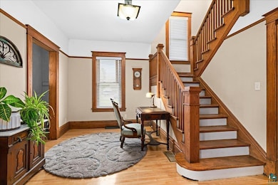 Stairs with wood finished floors and baseboards