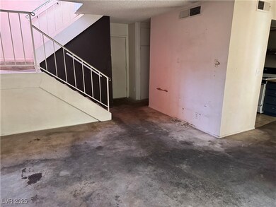 Unfurnished living room with stairs, a textured ce