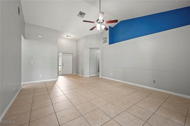 Unfurnished room with light tile patterned flooring, a ceiling fan, and high vaulted ceiling
