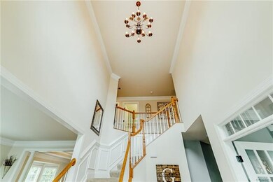 Light-filled 2-story foyer with chandelier and swe