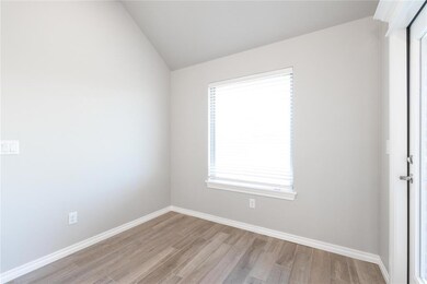 Unfurnished room featuring light wood finished floors and vaulted ceiling