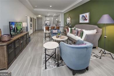 Living room with a tray ceiling and light hardwood