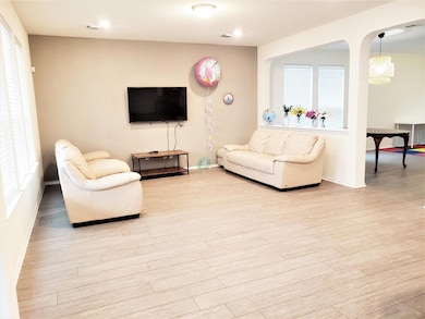 Living room featuring light wood-type flooring and arched walkways