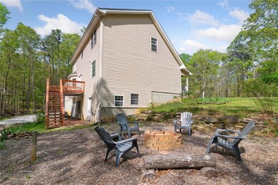 Rear view of house featuring stairway, a fire pit, and a deck