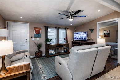 Living room featuring baseboards, vaulted ceiling,