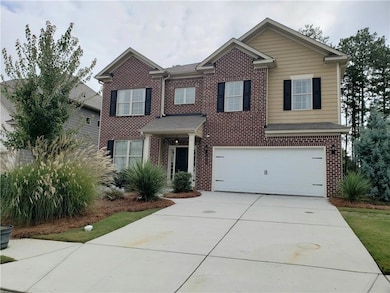 Traditional home featuring brick siding, concrete driveway, and a garage