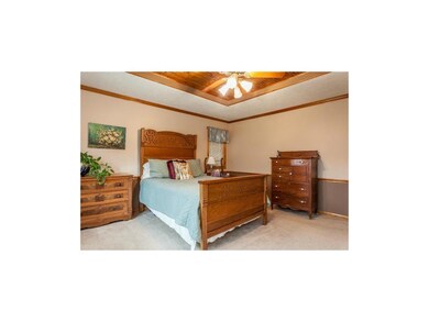 Large master bedroom with ceiling fan and wood pla
