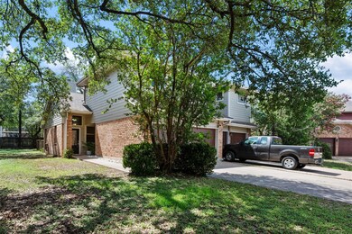 View of side of home featuring brick siding, driv