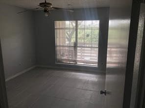 Unfurnished room with ceiling fan and baseboards