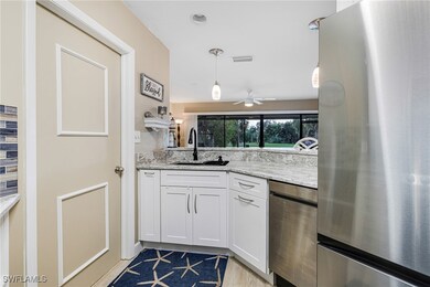 Kitchen with white cabinetry, sink, stainless stee