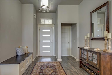 Entry is Impressive  with Designer Front Door, Modern Light Fixture and Beautiful Tile Flooring!