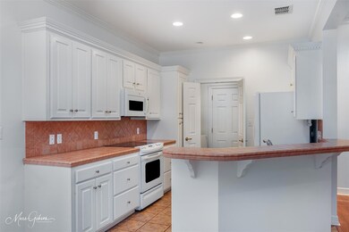Kitchen featuring white cabinets, a breakfast bar,