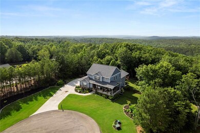 Aerial view of property and surrounding area featuring a forest