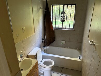 Full bathroom featuring tile walls, vanity, shower
