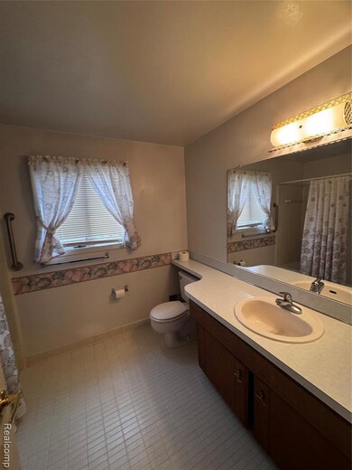 Bathroom with a shower with shower curtain and vanity