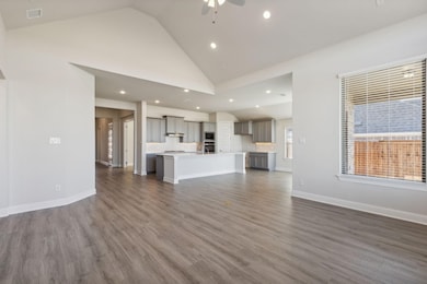 Unfurnished living room with dark wood-type flooring, high vaulted ceiling, recessed lighting, and ceiling fan