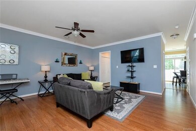Large Living room boasts crown molding, laminate w