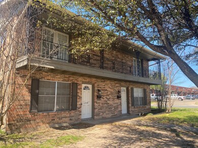 View of front facade with brick siding and a balco