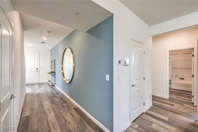 Corridor with wood finished floors, baseboards, an