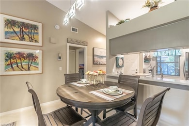 Dining area with lofted ceiling and light tile patterned flooring