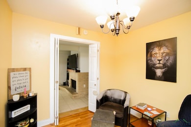 Living area featuring wood finished floors, a chandelier, and a fireplace