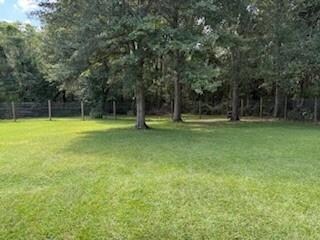 View of grassy yard with view of scattered trees