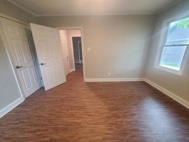 Bedroom 1 featuring crown molding and dark wood-ty
