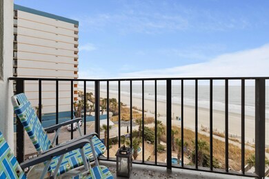 Balcony featuring view of water and beach