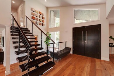 Foyer with stairway, wood finished floors, a high