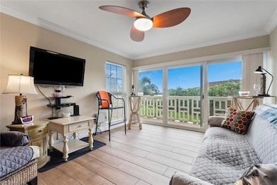 Living room featuring ornamental molding, light wo