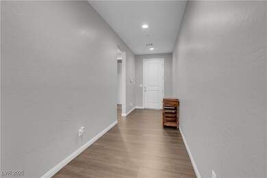 Hallway with baseboards, wood finished floors, and