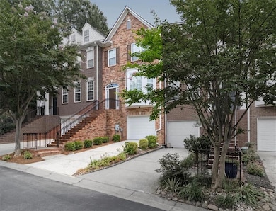 Townhome / multi-family property featuring brick siding, driveway, and a garage