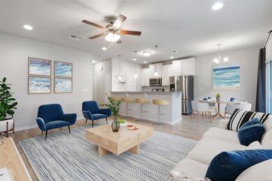 Living room with light wood-style floors, ceiling fan, and recessed lighting