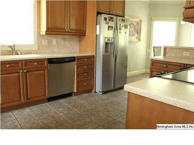 The kitchen has custom cabinets, tile backsplash, 