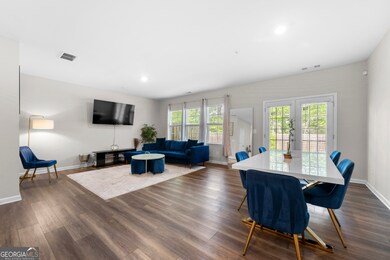 Main floor has a bright, open floorplan with a spacious living room, dining area and French doors to the outdoor garden and patio, overlooking a wooded area.