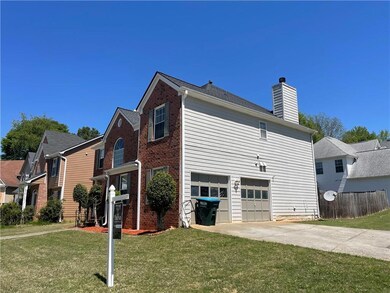 View of side of home with a yard, fence, an attach
